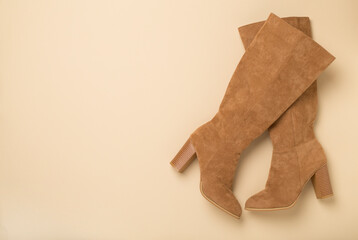 Wall Mural - Brown suede boots on color background, top view