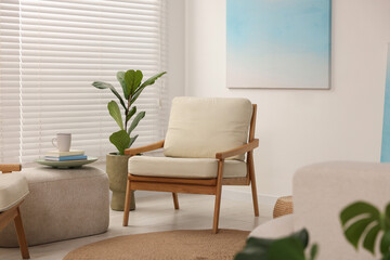 Sticker - Comfortable beige armchair, ottoman and houseplant in living room. Interior design