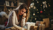 Beautiful sad young woman sitting on the floor in front of christmas tree 
