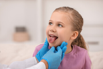 Canvas Print - Doctor examining girl`s oral cavity indoors, closeup