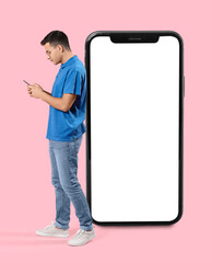Wall Mural - young man and big mobile phone on pink background