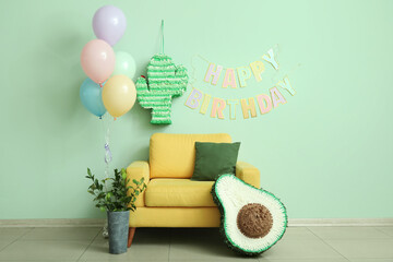 Poster - Yellow armchair, pinatas, balloons and garland near green wall in living room decorated for birthday