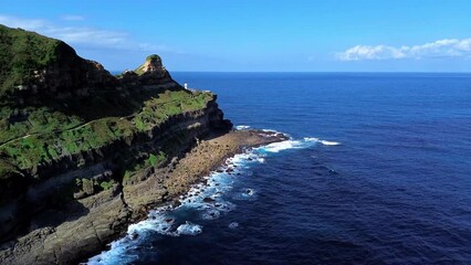 Wall Mural - Aerial 4k footage of Bitoujiao lighthouse, a famous scenery of Taiwan northeast corner. Birds eye view in Bitoujiao cape, Ruifang district, New Taipei, Taiwan.