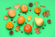 canvas print picture - Fresh pumpkins with different spices, chestnuts and autumn leaves on green background
