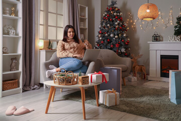 Sticker - Young woman with credit card and laptop shopping online for Christmas at home