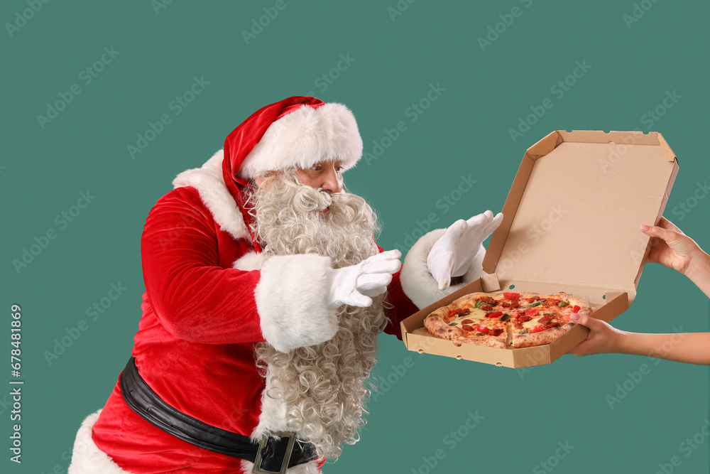 Santa Claus taking tasty pizza on green background