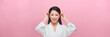 adorable smiling asian woman tuck hair behind ears on pink banner