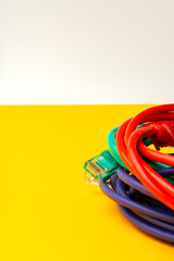 Network cable on yellow background studio shot