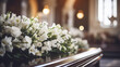 Closeup of modern Coffin in the church with fresh white flowers, candles, funeral ceremony. Organization of funerals, farewell to the dead, funeral service. 