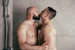 An attractive adult gay couple washes in the shower together. Love and relationship between two men.