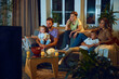 © master1305 - Boys and girl, sitting on couch with parents, other and father in living room, watching TV, eating snacks in the evening. Concept of family, leisure time, relaxation, childhood and parenthood