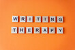 © Real_life - Word writing therapy. The phrase is laid out in wooden letters top view. Motivation. Orange flat lay background. Destressing hobby concept