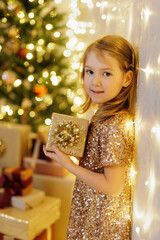 Wall Mural - Portrait of little girl holding present in hands