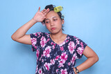 Fototapeta Panele - Asian housewife with hair curlers touching her head feeling tired and suffering from migraine