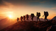 A team of hikers,  silhouetted against the setting sun,  celebrates their mountain conquest