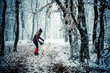 woman with dog walking in frost covered forest in winte