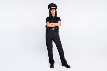 Wall Mural - Photo of adorable shiny young policewoman dressed black clothes headwear arms crossed isolated white color background