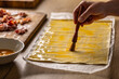© weyo - A female cook brushes puff pastry with egg