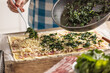 © weyo - The cook prepares mini pizza cakes, puts spinach on puff pastry with cheese and bacon.