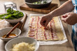 © weyo - The cook prepares mini pizza cakes, puts pieces of bacon on puff pastry.