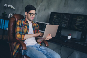 Portrait of smart happy web designer guy sitting chair use wireless netbook coworking modern office room indoors