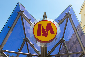 Entrance to underground in Warsaw, capital of Poland. Yellow round sing with red M letter and arrow