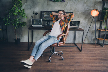 Wall Mural - Full size photo of satisfied positive front end developer sit chair hands behind head accomplish tasks workstation modern office indoors