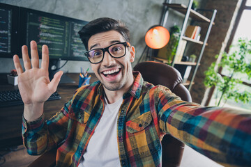 Portrait of cheerful friendly it guy sit chair take selfie arm palm waving hi loft workplace business center inside