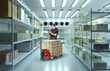 Man storekeeper in refrigerator. Guy conducts audit in refrigerated warehouse. Storage refrigerator with boxes on racks. Man looking for goods in refrigerator. Freezer warehouse employee with phone