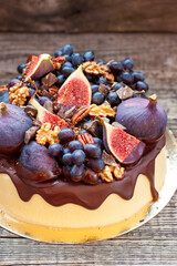 Wall Mural - Delicious vanilla cheesecake poured with melted dark chocolate, figs, grape, pecan nuts on the top. Harvest autumn decoration