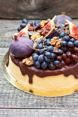 Wall Mural - Delicious vanilla cheesecake poured with melted dark chocolate, figs, grape, pecan nuts on the top. Harvest autumn decoration