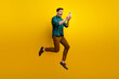 © deagreez - Photo of cheerful positive excited man dressed trendy outfit reading instagram telegram twitter post isolated on yellow color background