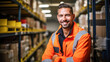 Warehouse worker smiling in an orange jacket.