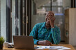 © Wasana - A senior black man in casual clothes is taking a break from paperwork. Using a laptop to make video calls