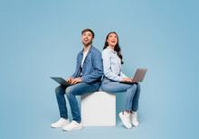 Couple With Laptops Look At Free Space On Blue Background