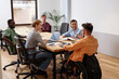 © AnnaStills - Group of business people having meeting in board room, they sitting at table and planning work together