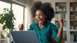 Ecstatic African American woman celebrates online job success.