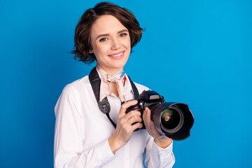 Sticker - Photo of charming positive girl toothy smile arms hold camera tied on neck scarf isolated on blue color background