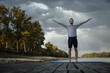 © sepy - Active man practicing yoga on the pier by the river