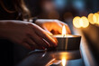 A close-up of a hand lighting a candle in memory of fallen heroes, capturing a moment of solemn reflection, creativity with copy space