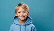 © Florence - portrait of a smiling little boy in a blue hoodie on a blue background