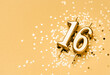 16 years celebration festive background made with golden candle in the form of number Sixteen lying on sparkles. Universal holiday banner with copy space.