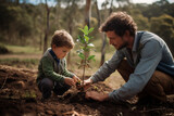 Fototapeta Miasta - Young father teaching his son the value of nature and environmental education through planting a tree. Bonding through generations, cultivating a sense of responsibility and sustainability