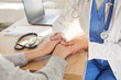 © Studio Romantic - Close up photo of young female physician holding hands her patient in palms. Woman doctor in white coat supporting her sick patient in hospital or clinic office after test results at checkup.