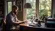 Focused man with a beard and glasses is working on a laptop in a well-lit home office