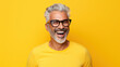 © PaulShlykov - Beautiful and happy blond hair senior man looking at camera isolated on yellow background