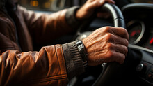 Close-up Of Hands Of An Older Man Driving A Car. Elderly Man Driving A Vehicle. Car Steering Wheel Driven By A Retiree. Taxi Driver Driving At Night. Vehicle Interior Driver Holding The Steering Wheel