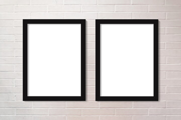 Brick wall painted in white two vertical picture frames