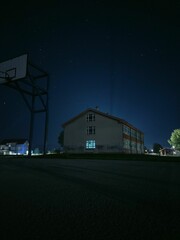 Poster - Vertical shot of a school building under the beautiful starry night sky