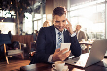 Businessman using smartphone in modern cafe